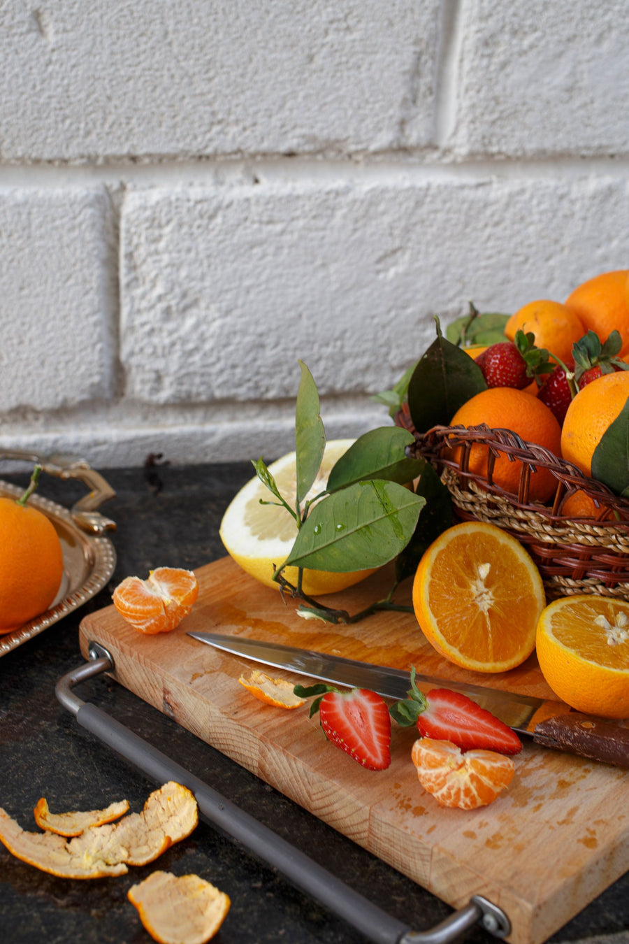 Orangen, Zitrusfrüchte und Erdbeeren auf einem Holzbrett