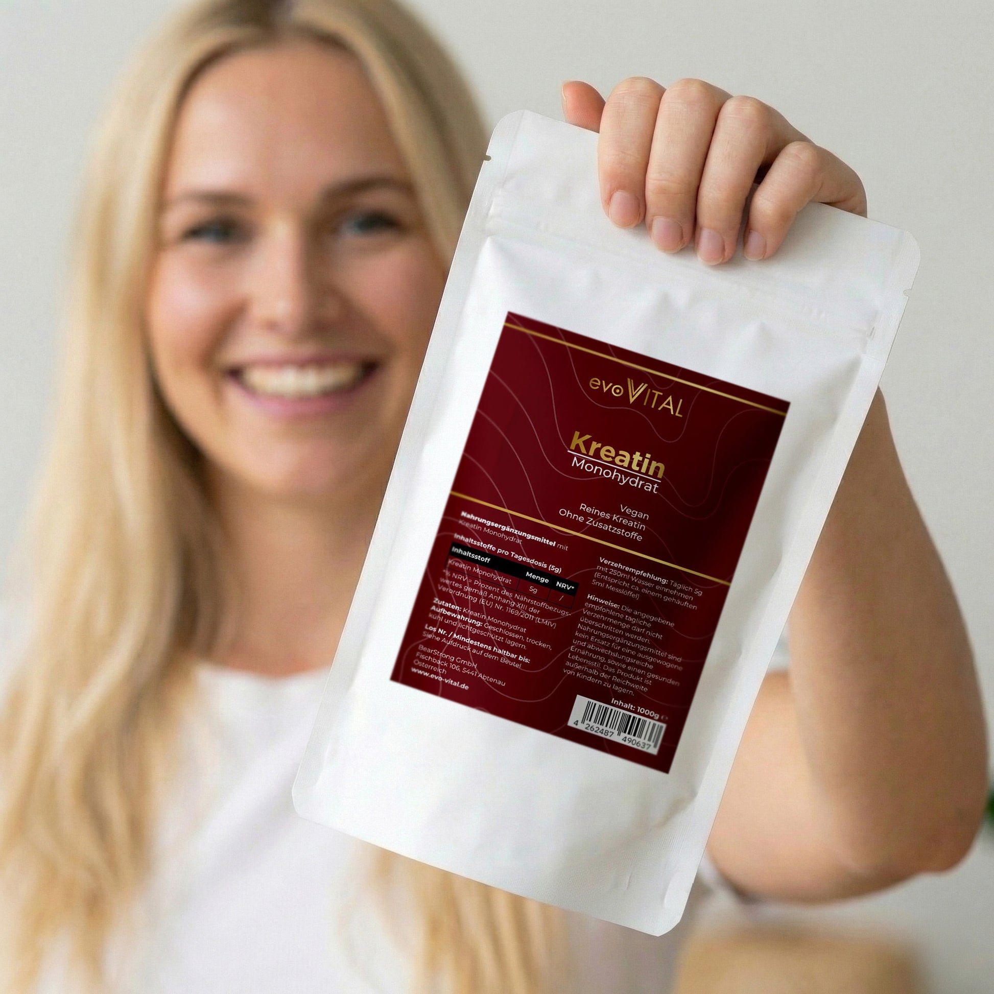 Eine Hand hält den Doypack des Kreatin-Monohydrats mit reinem Kreatin-Pulver für Leistungssteigerung und Muskelkraft – 200 Portionen.