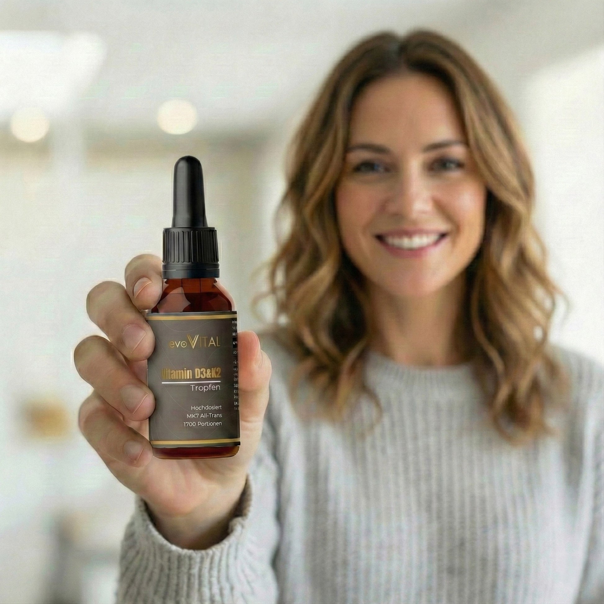 Eine Hand hält die Flasche der Vitamin D3 & K2 Tropfen in MCT-Öl für Knochen, Immunsystem und Muskelfunktion – 1700 Portionen.